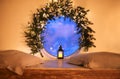 Christmas time. Vintage glowing lantern by round window decorated with tree branch and xmas lights Royalty Free Stock Photo