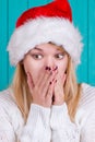 Christmas time. Young woman wearing santa claus hat red dress on blue background Royalty Free Stock Photo