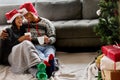 Christmas is a tonic for our souls. Shot of a young couple sitting on the floor at home. Royalty Free Stock Photo