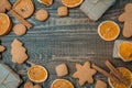 Christmas top view over a brown wooden background with gift boxes packed in a craft paper with dryed oranges, cookies