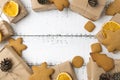 Christmas top view over a white wooden background with gift boxes packed in a craft paper, cookies, dryed oranges, pine