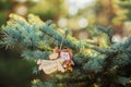 Christmas toy - beautiful wood angel on green spruce and lights background. Place for text.