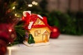 Christmas toy house with a red roof and windows with yellow light