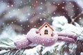 Christmas Toy house is wrapped in a warm scarf, it`s snowing.on