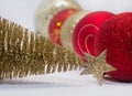 Christmas toy, a lot of shiny red, gold and silver balls and golden tree. New Year. On a gray background Royalty Free Stock Photo
