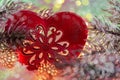 Christmas toy red heart with ornament on the snow. Luminous yellow garland and pine branches on ice crystals.  Macro. New year. Royalty Free Stock Photo