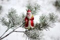 Christmas toy red Santa Claus on a natural branch with pine tree needles in the snow background. Concept for New Year, Christmas Royalty Free Stock Photo