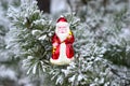 Christmas toy red Santa Claus on a natural branch with pine tree needles in the snow background. Concept for New Year, Christmas Royalty Free Stock Photo