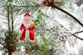 Christmas toy red Santa Claus on a natural branch with pine tree needles in the snow background. Concept for New Year, Christmas Royalty Free Stock Photo