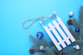 Christmas toy sledge with fir-tree branch on a blue background Royalty Free Stock Photo