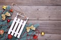 Christmas toy sledge with fir-tree branch on a grey background Royalty Free Stock Photo