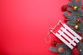 Christmas toy sledge with fir-tree branch on a red background Royalty Free Stock Photo