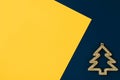 Christmas toy stylized gold Christmas tree on a colorful yellow and blue background. Copy space. flat lay Royalty Free Stock Photo