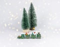 Christmas toy train and tiny fir trees among garland lights. Composition for postcard