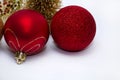 Christmas toy, two shiny red balls and a golden Christmas tree in the background. New Year. On a gray background Royalty Free Stock Photo