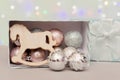 Christmas toys, balls and a horse on the background of bokeh of Christmas lights lie in an open box. Concept - New Year card, Royalty Free Stock Photo