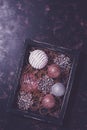 Christmas toys balls and snowflakes in a wooden box on a rustic background. Top view, copy space, purupr toned Royalty Free Stock Photo