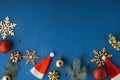 Christmas toys on the blue background. Festive Christmas background with wooden snowflakes, tree branches and Santa hats. Flat lay Royalty Free Stock Photo