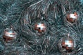 Christmas toys in the form of disco balls lie on a festive silver tinsel, top view