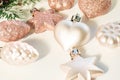 Christmas toys - pink shiny balls on a light background and a defocused foreground. New Year or Christmas card, invitation