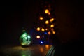 Christmas toys on table at decorative fir-tree blurred with lights. Making a Christmas tree on table. Empty space. Useful as greet Royalty Free Stock Photo