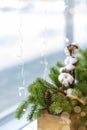 Christmas tradition decoration on a windowsill in a cafe. Spruce needles, cinnamon, cotton in wooden box, vertical photo