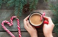 Christmas tradition drink. Mug hot coffee with milk, red candy cane on the wooden background. New Year. Holiday card. Rustic style Royalty Free Stock Photo