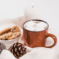 Christmas traditional hot drink cocoa with marshmallow and cookies with chocolate drops in red cup, cones, candle Royalty Free Stock Photo