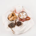 Christmas traditional hot drink cocoa with marshmallow and cookies with chocolate drops in red cup, cones, candle Royalty Free Stock Photo