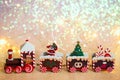 Christmas train on a shiny background. Toy wooden train with gifts, Santa, parcels and Christmas tree