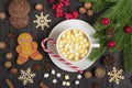 Christmas treats - gingerbread and hot chocolate with marshmallows, cinnamon, cloves on a wooden table decorated with Christmas de