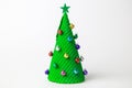 Christmas tree abstract made of ice cream cone and miniature multicolored baubles with star on white