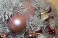 Christmas tree artificial white, decorated with toys of pink and gold tones close-up as a background. Royalty Free Stock Photo