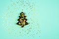 Christmas tree baking mold with colorful sparkles inside on a light blue background. Flat lay. View from above. Place