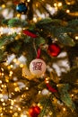 Christmas tree ball with happy new year inscription hanging on Christmas tree with lights