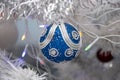 Christmas tree balls hang on the white artificial Christmas tree, holiday decorations. Royalty Free Stock Photo