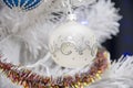Christmas tree balls hang on the white artificial Christmas tree, holiday decorations. Royalty Free Stock Photo