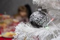 Christmas tree balls hang on the white artificial Christmas tree, holiday decorations. Royalty Free Stock Photo