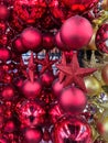 Christmas tree balls and star ornaments in red, maroon or dark pink and gold color hanging in a christmas decoration store Royalty Free Stock Photo