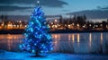 Christmas tree with blue and white lights, blurred icy lake background Royalty Free Stock Photo