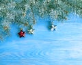 Christmas tree branch card border on blue wooden background, snow