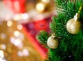 Christmas tree branch. Cozy . Two small cristmas-tree balls with golden glitter hang on needles of lush green. The background is Royalty Free Stock Photo