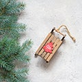 Christmas tree branch on a gray background, festive mood, gift season. Decorative wooden sled for decoration , toys. Royalty Free Stock Photo