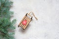 Christmas tree branch on a gray background, festive mood, gift season. Decorative wooden sled for decoration , toys. Royalty Free Stock Photo