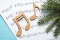 Christmas tree branch, notes and music sheets on wooden table, flat lay Royalty Free Stock Photo