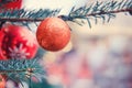 Christmas tree branch with orange bauble and bokeh, copy space. Xmas decorations on new year Royalty Free Stock Photo