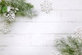 Christmas tree branch with pine cone in snow and retro style clock on a white wooden background. Winter or Christmas festive Royalty Free Stock Photo