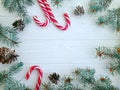 Christmas tree branch, pinecone, snow candy on a white wooden background