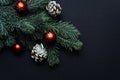 Christmas tree branch with red Christmas balls on a black background. Xmas greeting card with space. Flat lay, top view Royalty Free Stock Photo