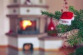 Christmas hat 2024 on fir tree branch and blur burning fireplace background. Royalty Free Stock Photo